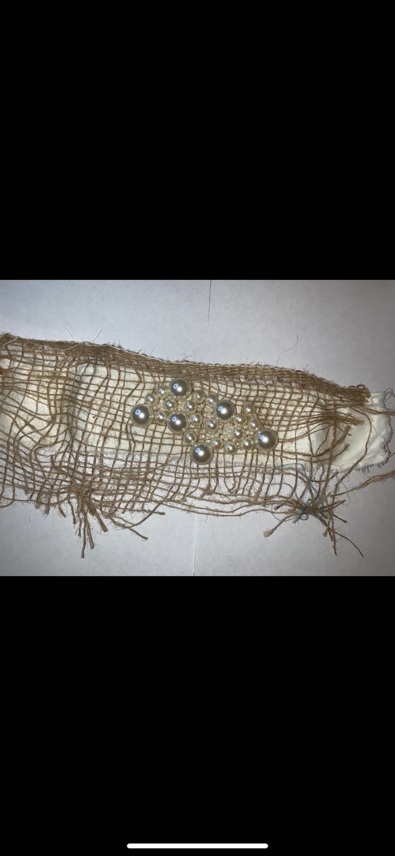 By Clara Weinmann. The following image is an embroidery piece using hessian and embellishments. I paired these materials together to show the contrast between the different emotions I felt.
